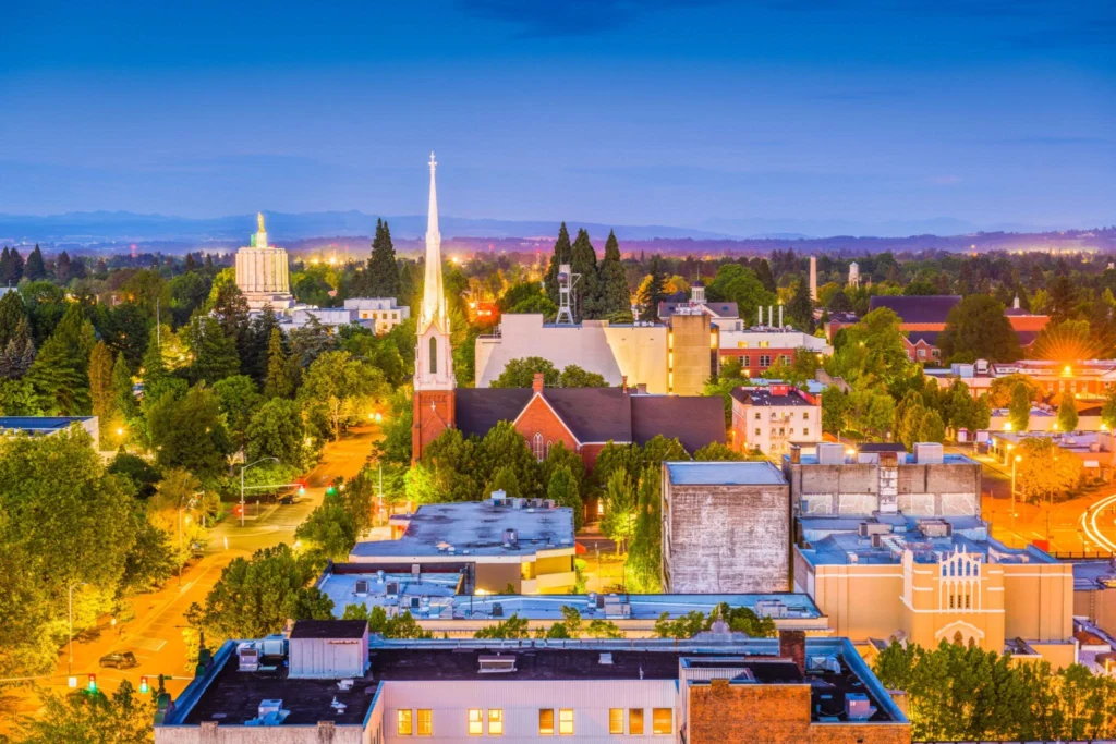 A city skyline at dusk featuring a church and clock tower, with a hint of Oregon's immigration lawyer services nearby.