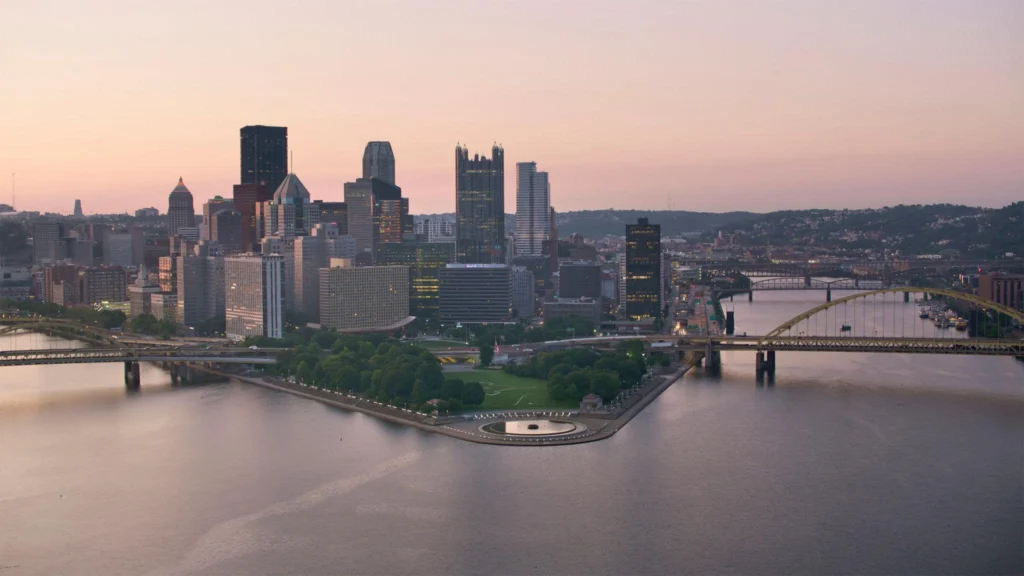 A city skyline featuring a river and bridge, symbolizing connection, with a focus on immigration law in Pennsylvania.