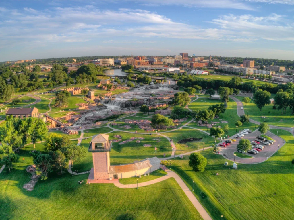 Aerial view of a park surrounded by a cityscape, highlighting green spaces amidst urban development in South Dakota. immigration lawyer south dakota