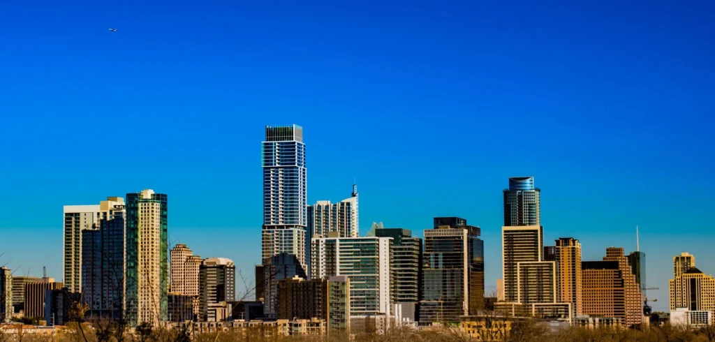A city skyline featuring tall buildings and trees, representing urban life in Texas, home to an immigration lawyer.