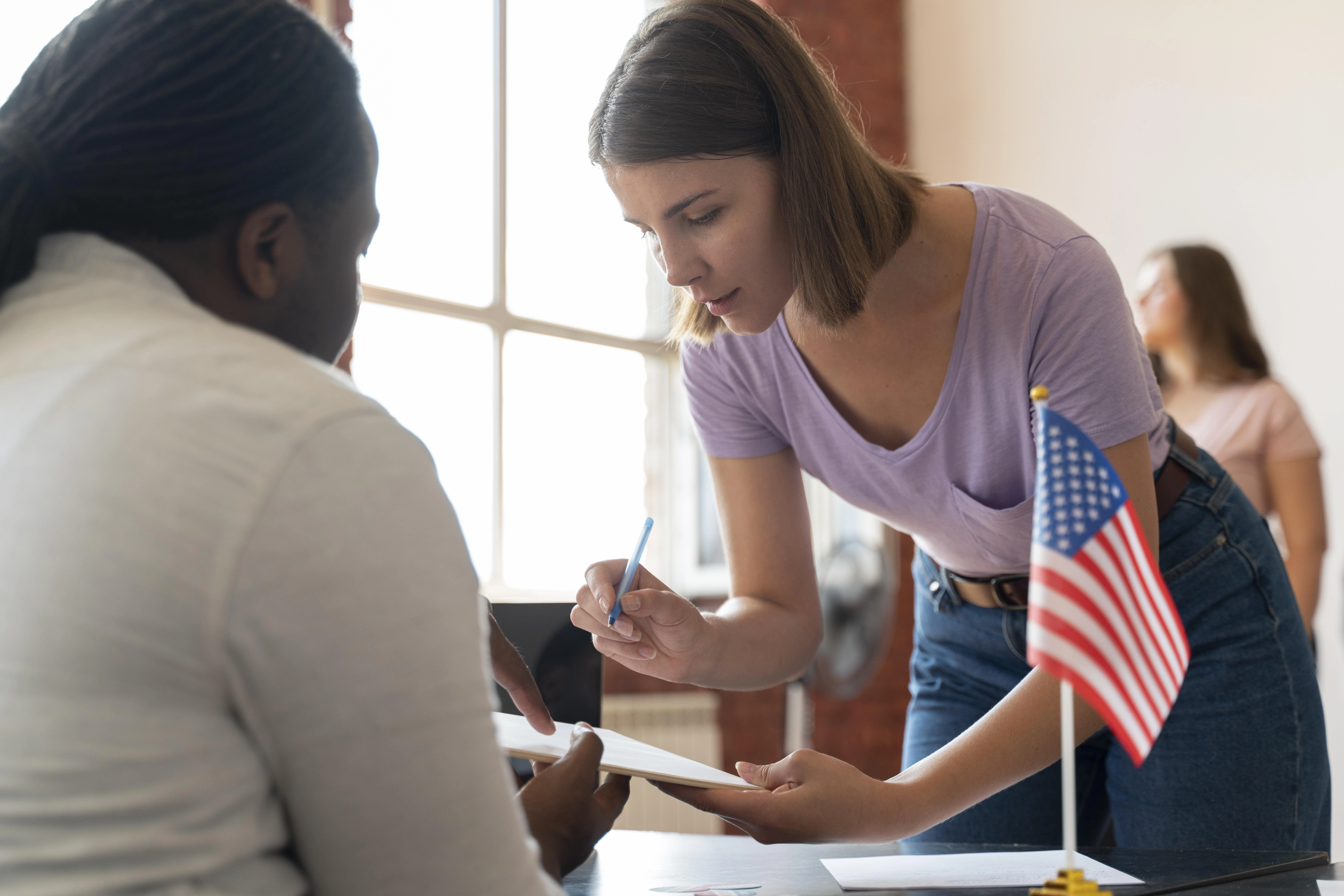 A woman completing paperwork with an American flag nearby, emphasizing the urgency for U Visa and VAWA legal assistance.