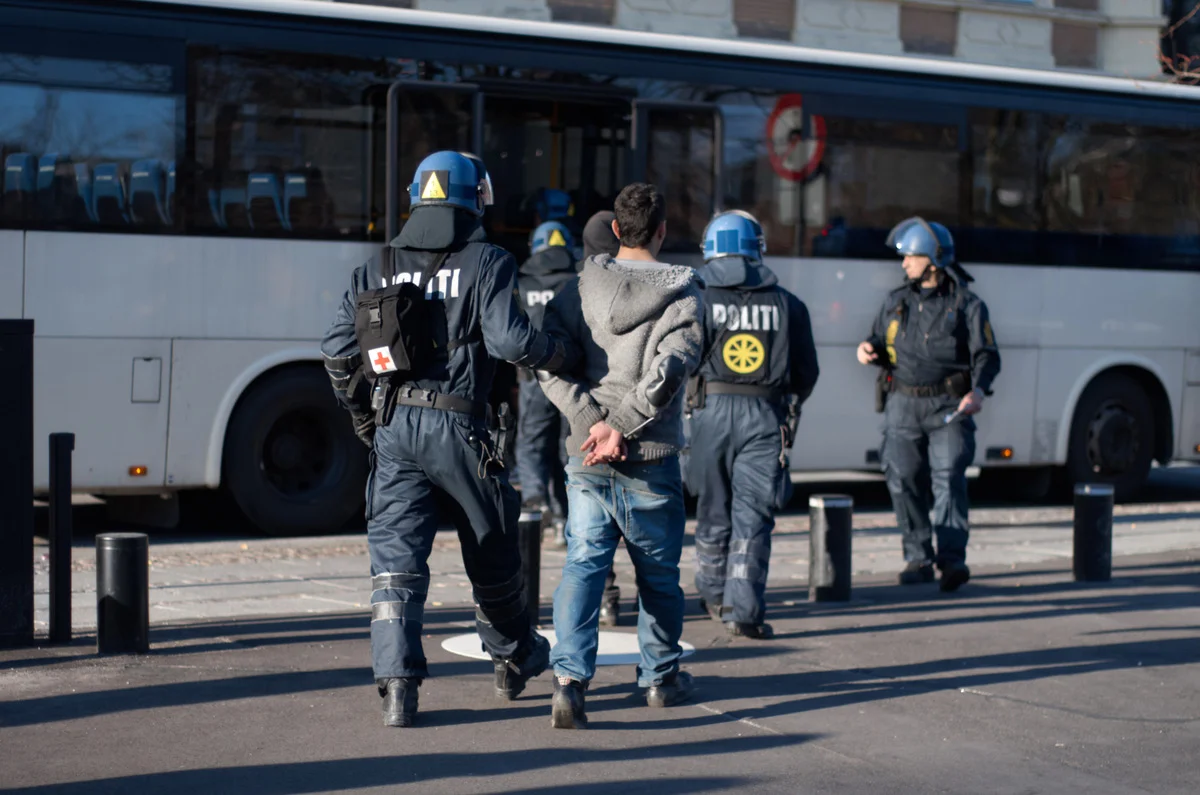 Deportation Defense Lawyer Near Me in California - Police officer, arrest and person in street for crime, safety and bus for crowd control in city.