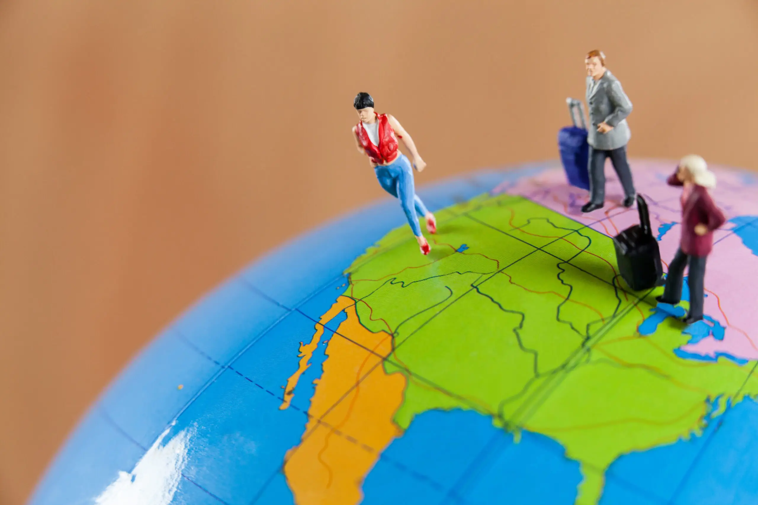 Grupo diverso de inmigrantes de pie frente a una bandera estadounidense, que representa el Estatus de Protección Temporal (TPS), las fechas de finalización y las actualizaciones de la política de inmigración en los Estados Unidos para 2026.